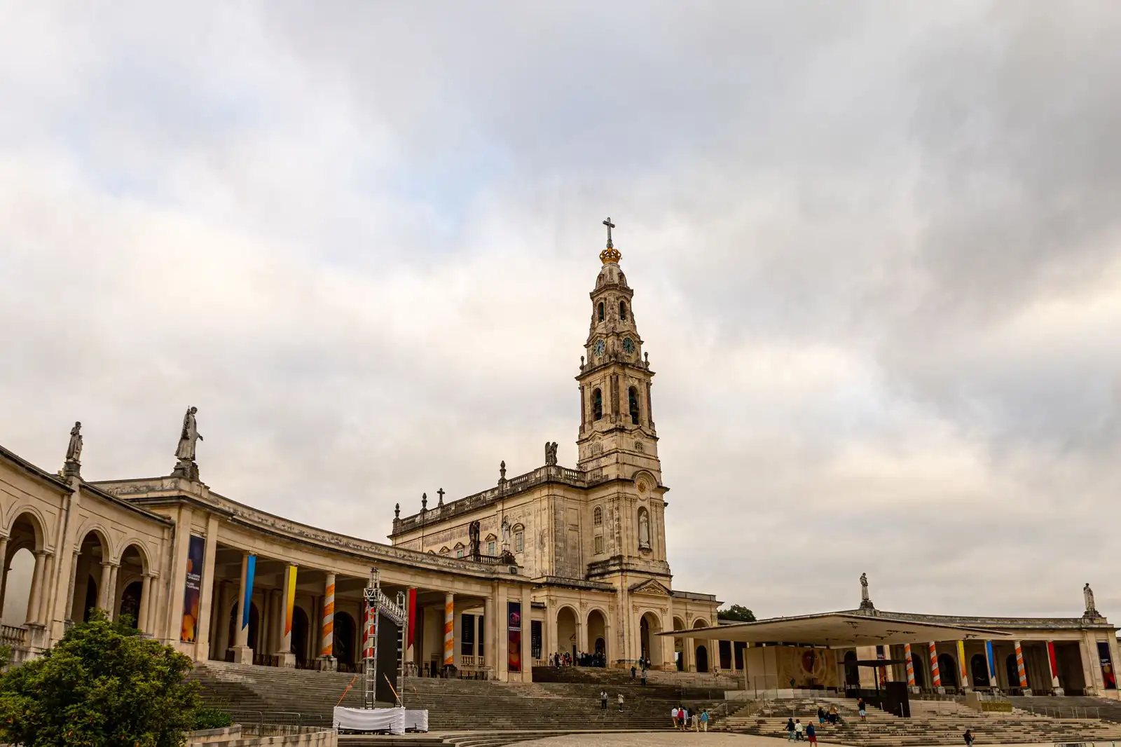 The Sanctuary of Fátima's architectural grandeur captured under a dramatic cloudy sky in Portugal.