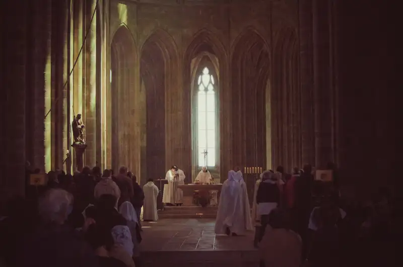 People attending a religious ceremony inside a grand church